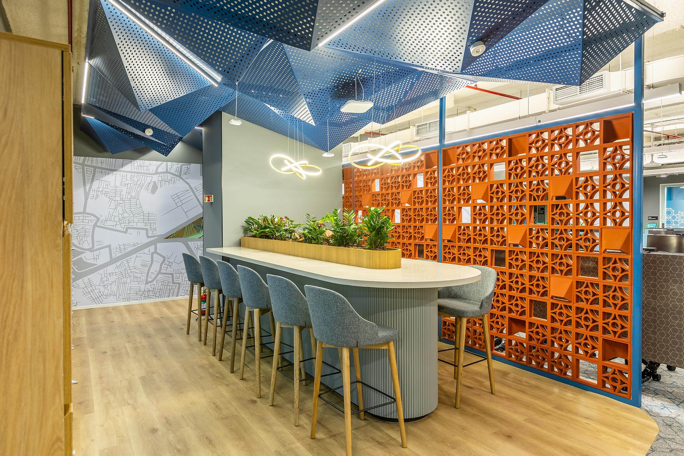 Bar height counter with stools, planter divider, orange patterned screen, and blue ceiling panels